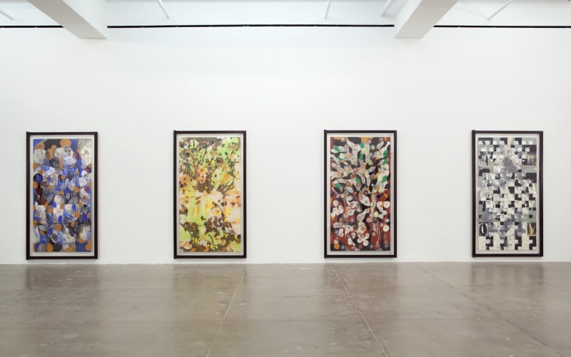 Four large vertical paintings with geometric shapes, flower-like patterns and monochromatic color schemes hang on a white wall. 