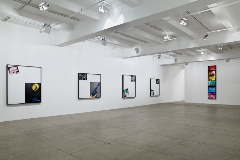 Four large framed photographs depict collage-like diptychs on the left wall; six framed images of foreheads colored like the rainbow are stacked on the right wall. 