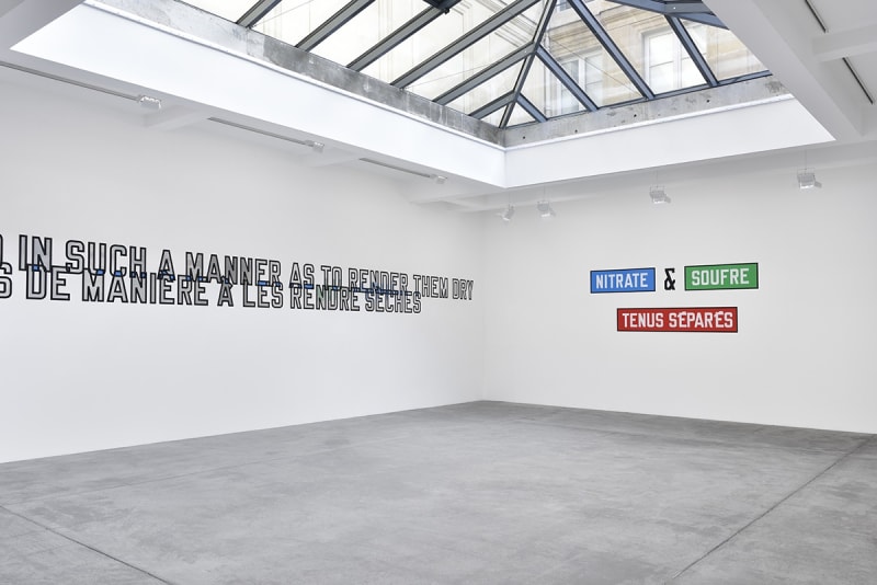 Multicolored text on the wall which reads "NITRATE & SOUFRE TENUS SEPARES". Additional text is cut off to the left.