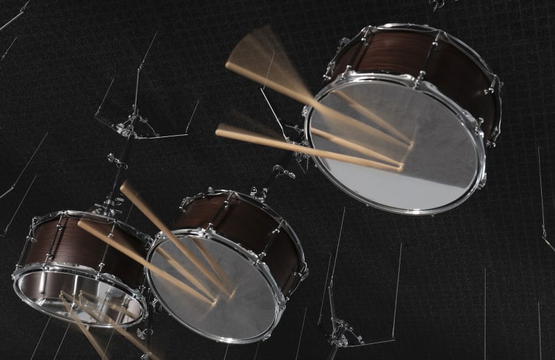 3 snare drums suspended upside down from a black ceiling.