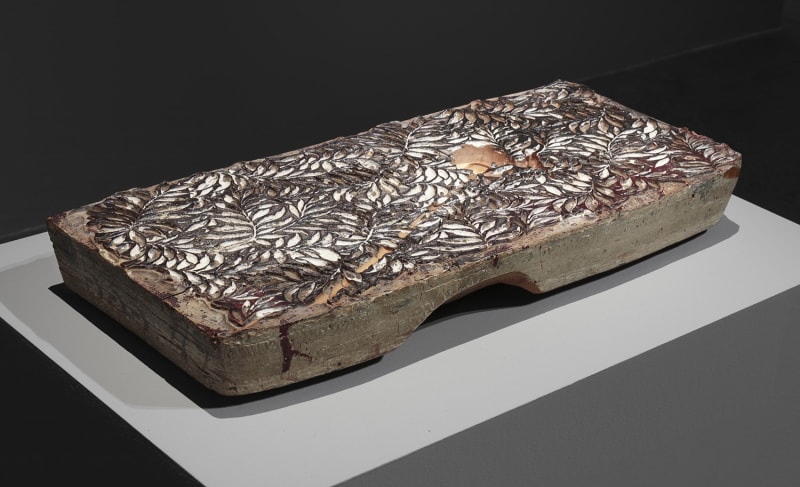 A pattern of leaves carved into a stone slab.