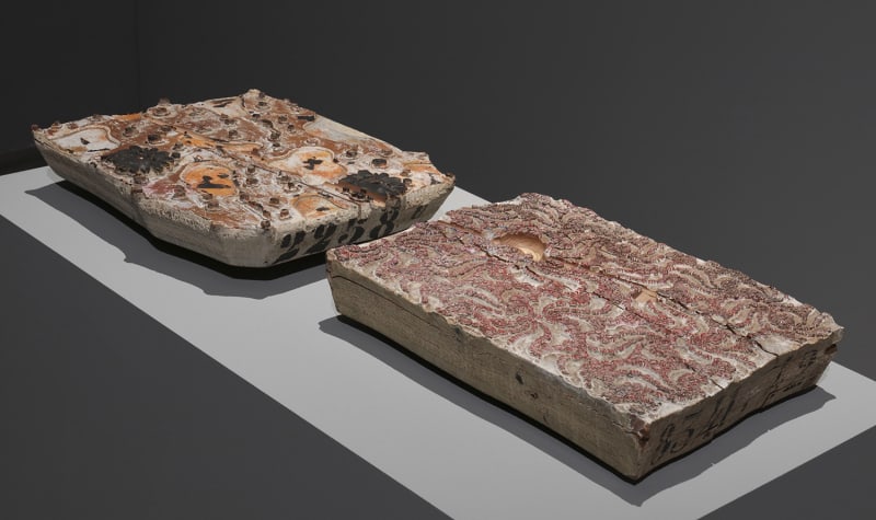 Organic patterns for relief printing carved into a wooden and stone slab.