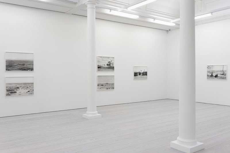 installation view of black and white photographs of war simulation by An-My Le