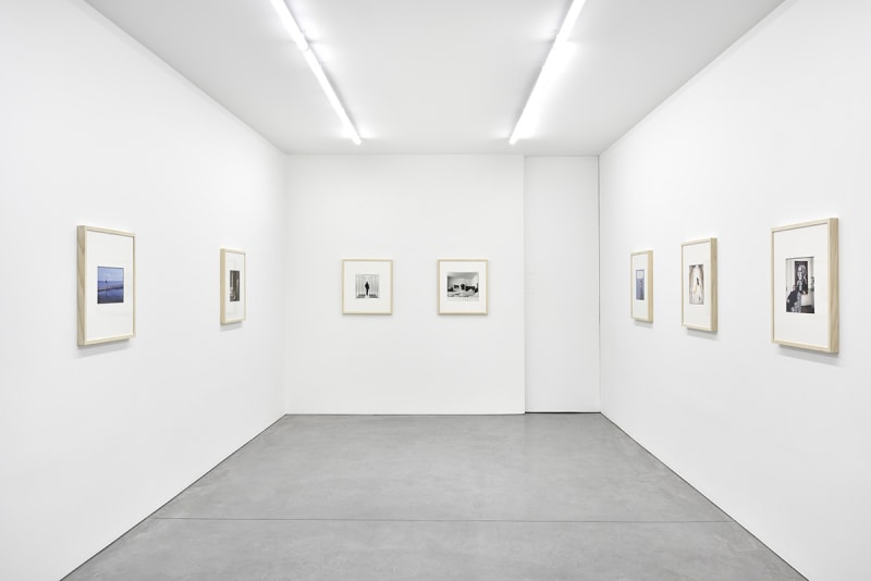 7 framed artworks hang in a gallery.