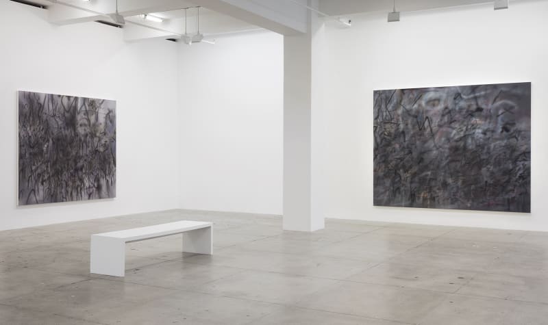 2 abstract paintings hang in a white gallery space with a white bench.