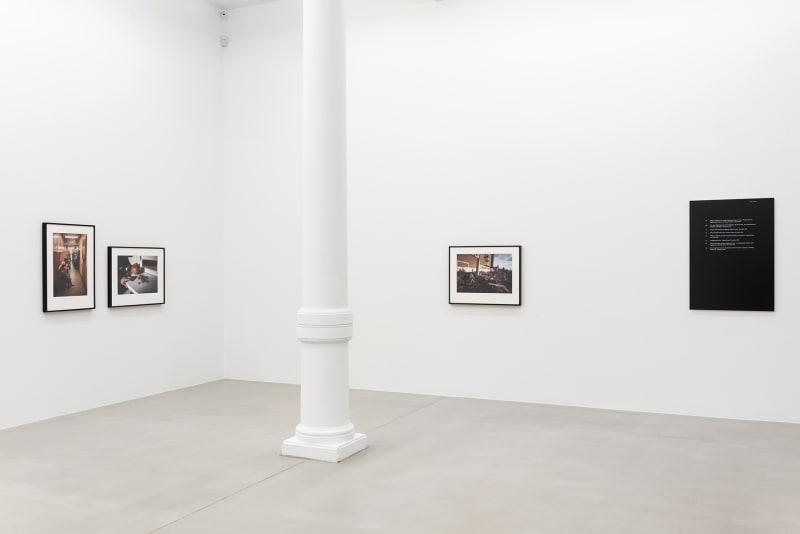 Four small photographs on gallery wall with a pillar between them.