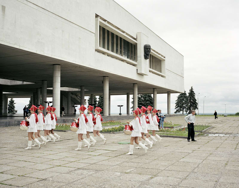 Simon Roberts A marching school band pass under Lenin, Ulyanovsk, Volga, 2005