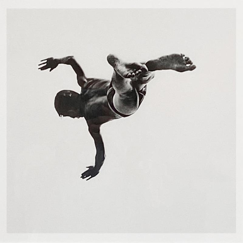 a photograph of a man falling through white space, there is no horizon line or any other point of reference