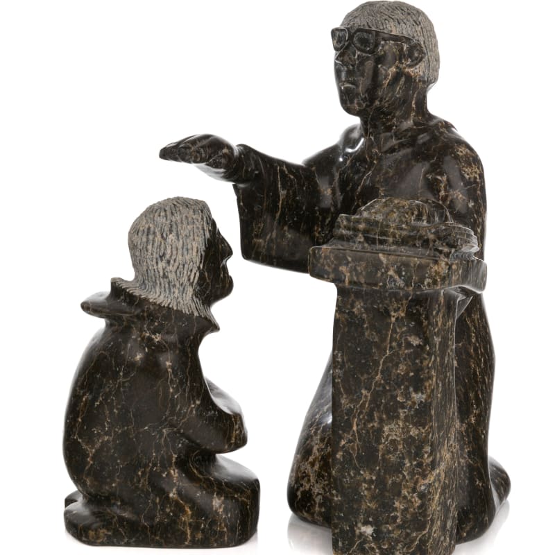 ADAMIE ASHEVAK (1959-) KINNGAIT (CAPE DORSET)  Priest Blessing Parishioner, 1990s / 2000s  stone and black, dimensions variable, the priest: 13.5 x 8 x 8.25 in (34.3 x 20.3 x 21 cm) / the parishioner: 9.75 x 3.25 x 5.25 in (24.8 x 8.3 x 13.3 cm)  each signed, "ᐊᑕᒥ / ᐊᓱᕙ".