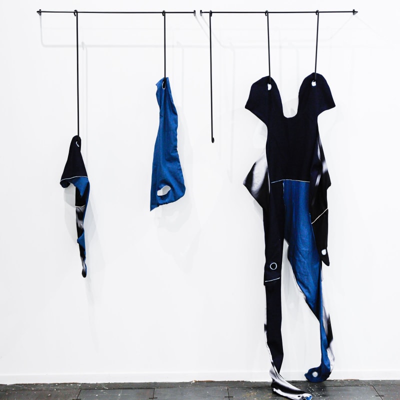FannyGicquel,theskinsfrom other, 2022, steel, painting, printed cotton fabric, blue jean,variabledimension(systemto hanging in steel is 100x15 cm). Courtesy of the artist and Hua International Booth designed by Krista Xueying Yu