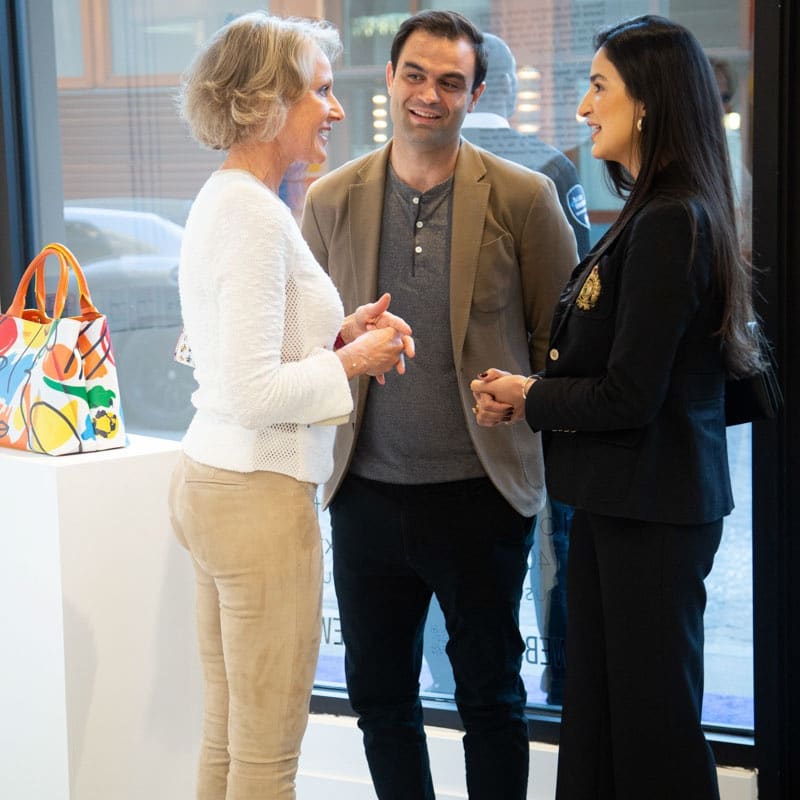 People talking at Carousel Fine Art's gallery space in Buckhead Village, Atlanta during the Caroline Dechamby Retrospective.