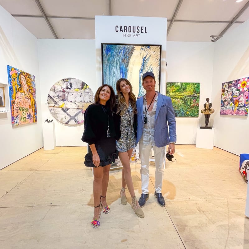 People posing in front of Carousel Fine Art's gallery both at the Hampton's Art Market, 2021.