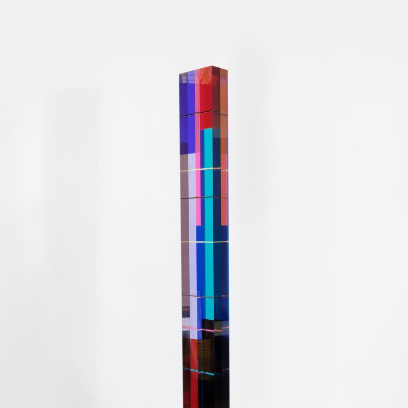 A tall narrow sculpture constructed of colorful acrylic