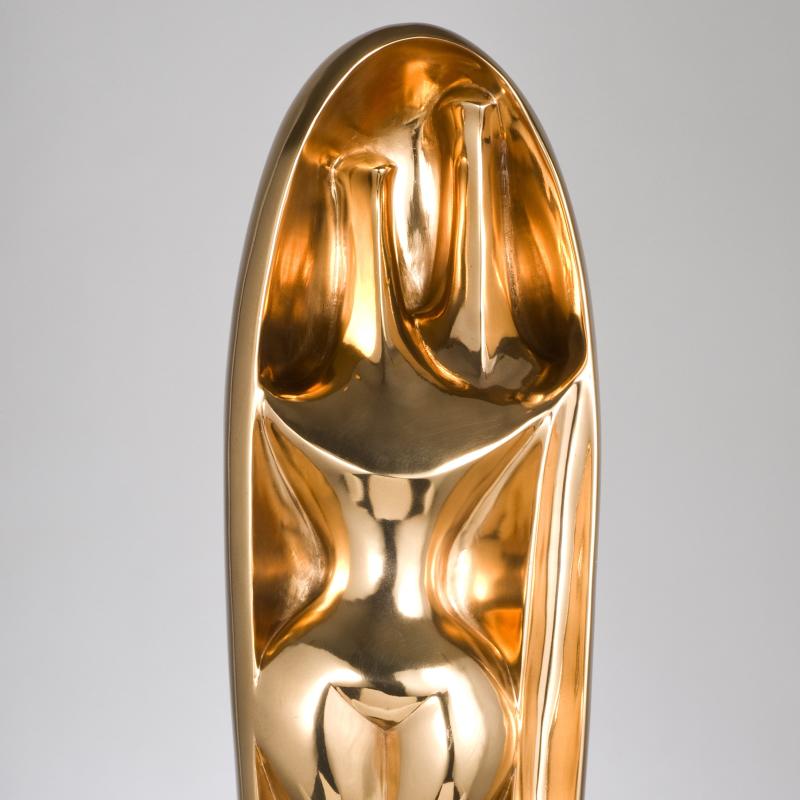 A polished bronze sculpture, two abstracted figures