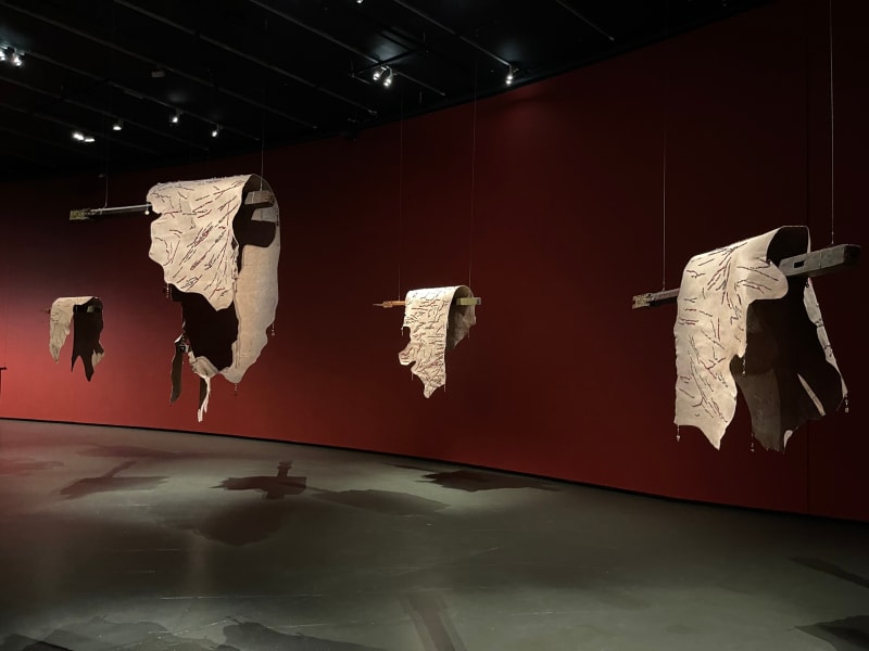 Citra Sasmita Prologue (Cowhide 1), 2024 Beaded cow hides hung on antique wooden pillars with aluminium saddles. Part of larger installation comprising 5 pieces each 100 x 180 cm (Cowhide) , Wood length 170/180 cm