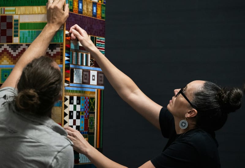 Dyani White Hawk tests the installation of two of the panels on her artwork. She enlisted the help of her community to bead the piece. (Richard Tsong-Taatarii/The Minnesota Star Tribune)