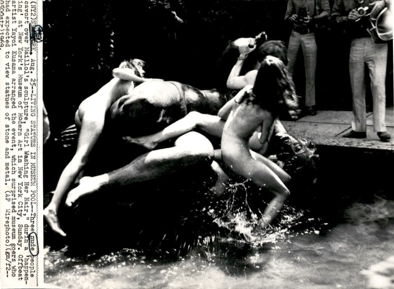 Black and white photograph of many naked people gathered for one of Kusama's happenings