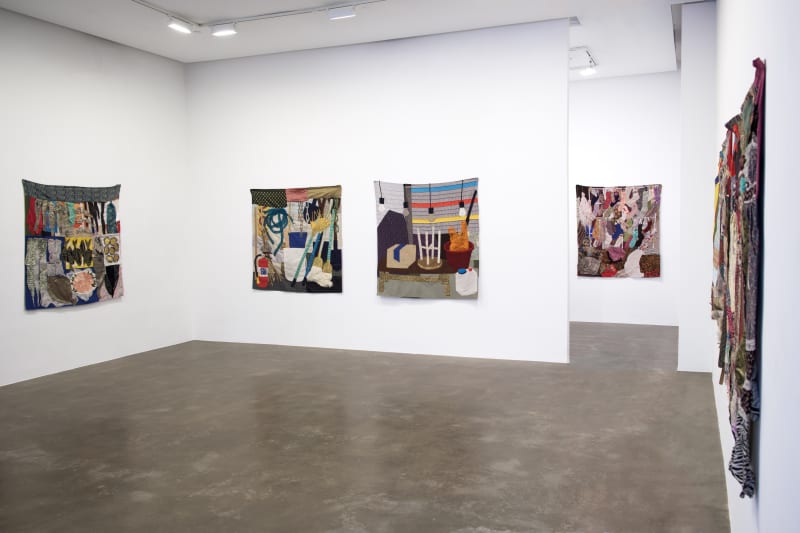 Main gallery installation view of Woomin Kim's exhibition showing multiple wall hanging fabric quilts