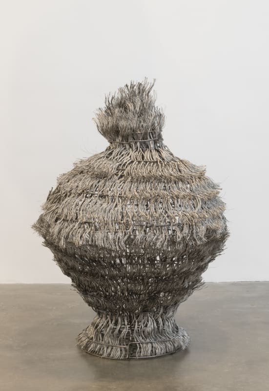 Photo of a Maren Hassinger sculpture made from woven steel wire rope in the shape of a vessel