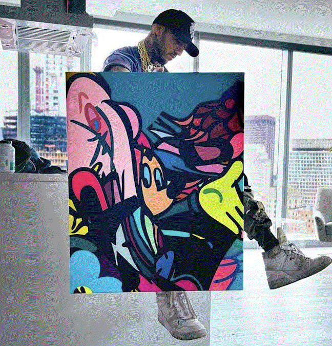 Timmy Sneaks holding one of his paintings.