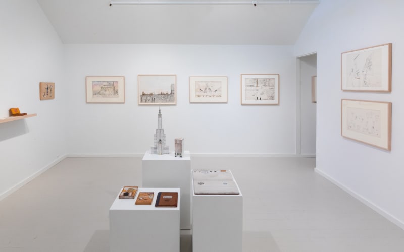 A group of Saul Steinberg drawings on the walls, accompanied by a large group of Steinberg objects on various plinths in the center.