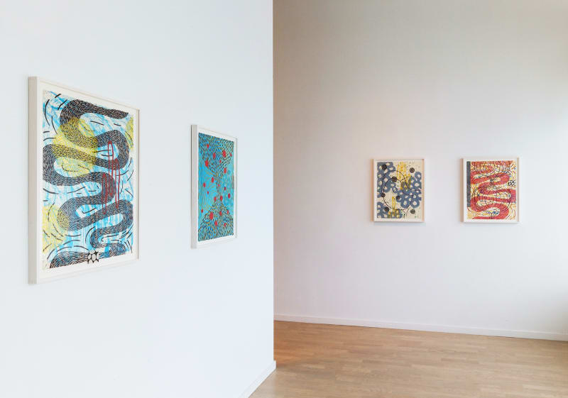 Four abstract and colorful works on paper by Sue Heatley: two on the right wall shown most clearly in the image, and two on the left wall, slightly obscured by the angle.