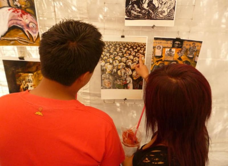 Photograph of two people looking at the installation of an artwork by the artist at the Tiempo Animal Exhibition, Mexico City, 2018 