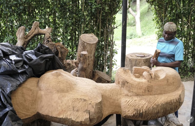 Liliane Nabulime with a wooden sculpture piece at her workshop in Kyanja