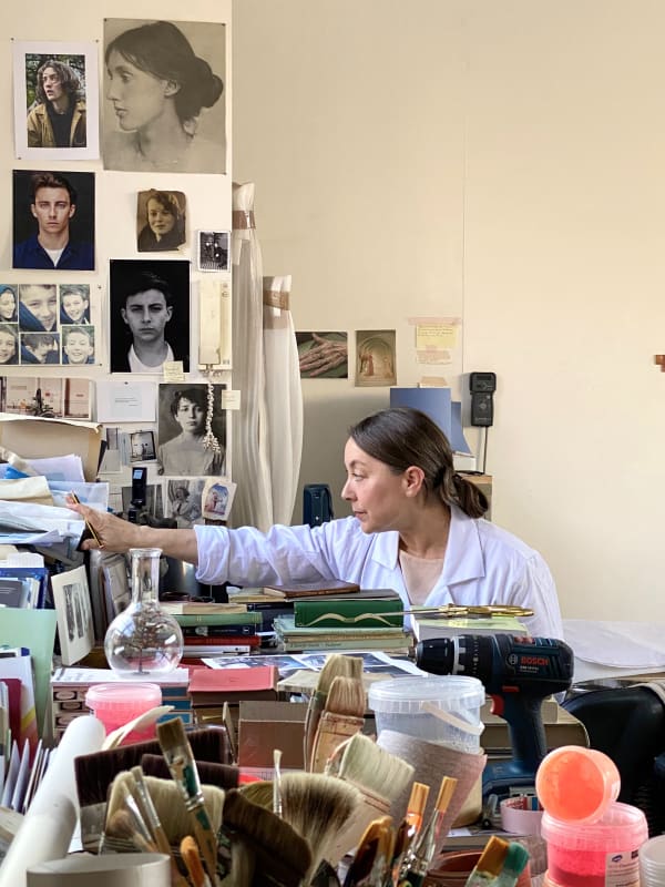 Portrait of artist Jane Bustin seated in her studio.