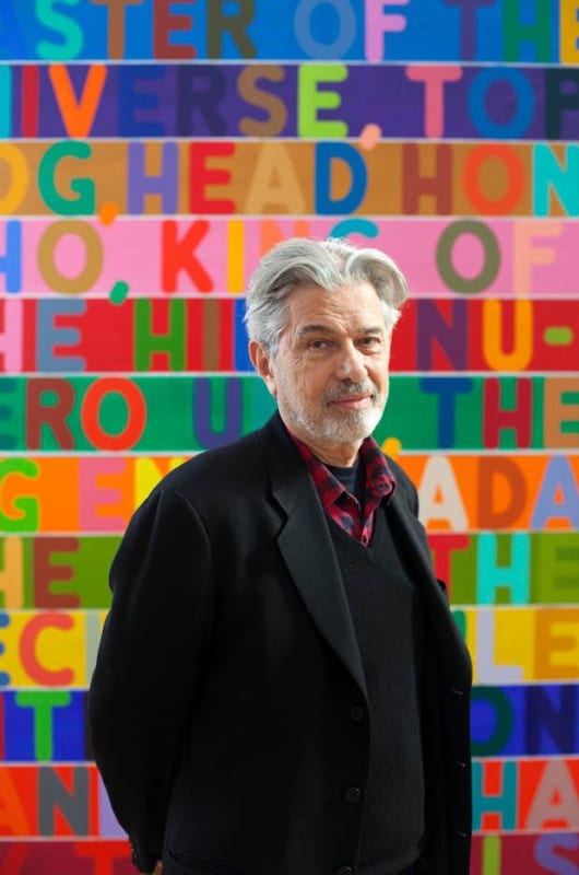 Mel Bochner standing in front of colorful text artwork