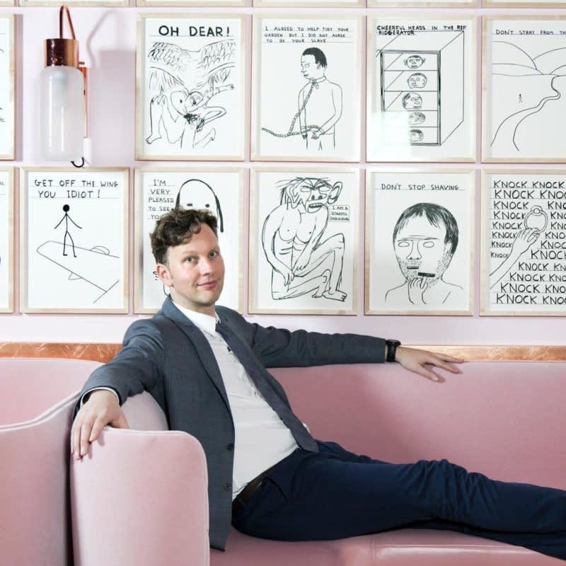 David Shrigley with his artwork collection on display, featuring humorous and quirky illustrations