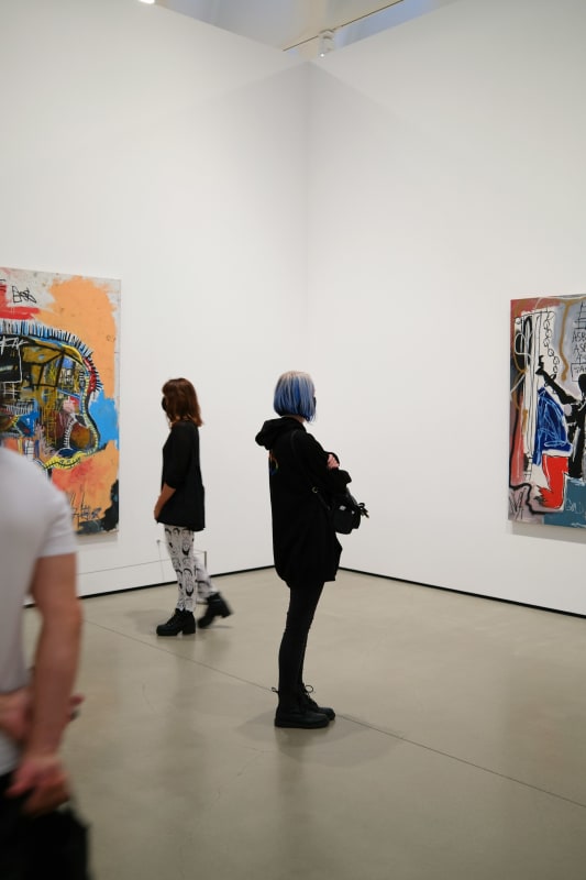 Woman looking at a Basquiat in an art gallery