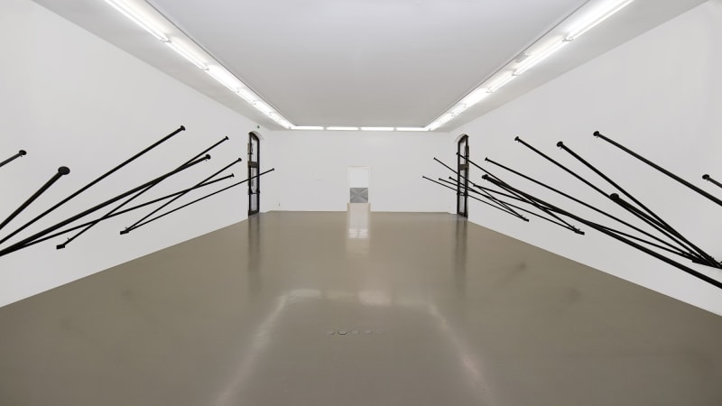 © Blaise Adilon - Latifa Echakhch - Latifa Echakhch, Fantasia (Empty Flag, Black) 4 walls in a room, 2007 Installation, 22 porte-drapeaux noirs fixés au mur sans drapeau Bois, plastique et métal peints en noir.