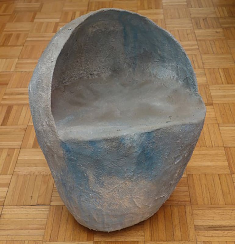 Biomorphic sculpture painted with light blue and white colors in the shape of a rock with cutout