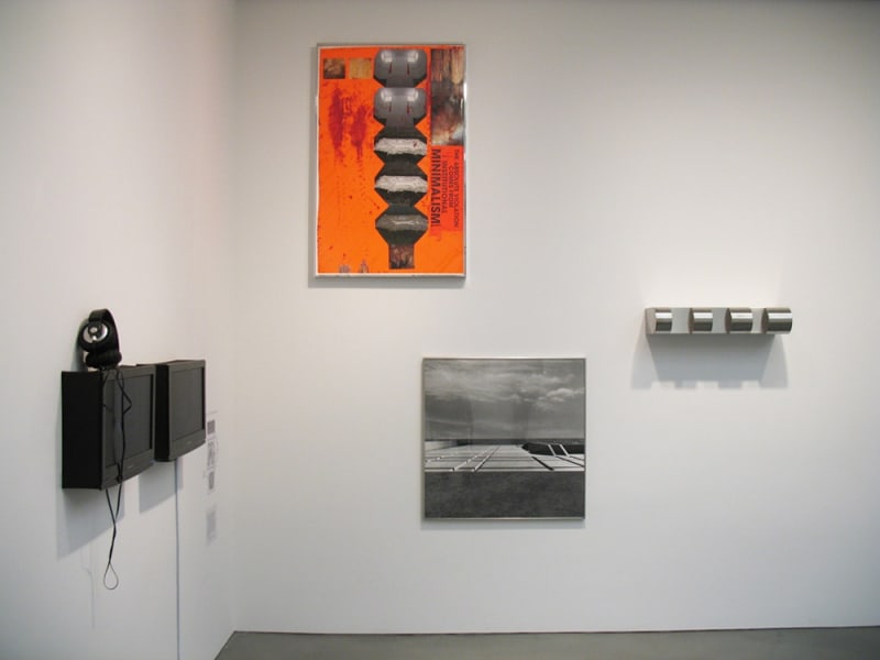Gallery installation view of abstract paintings, found object wall sculptures, photograph of building