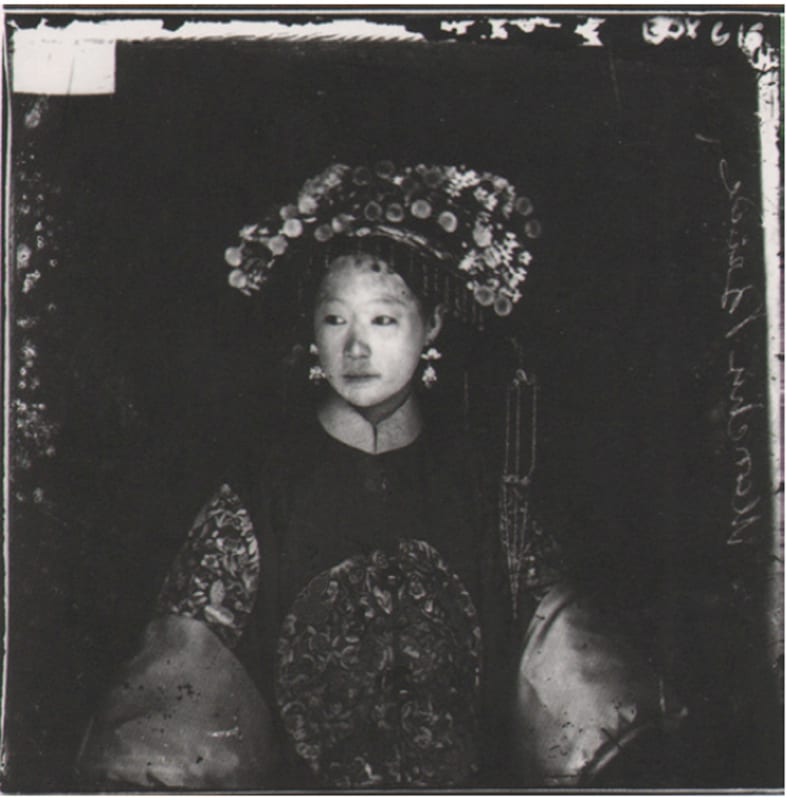 Period photograph of a young Chinese bride, wearing an elaborate head-dress and an embroidered outfit