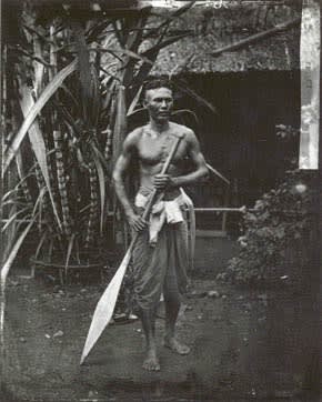 Period photograph of young man, barefoot, with paddle