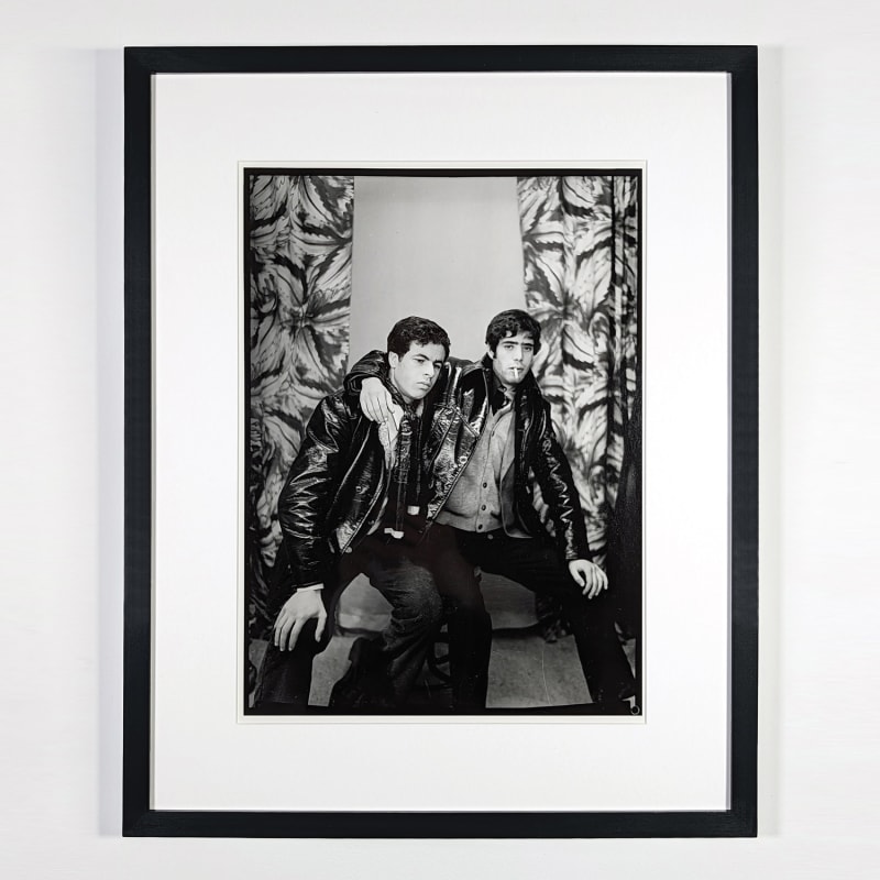 Black and white photograph of two men in leather jackets posing in a photo studio in Ain Beida, Algeria