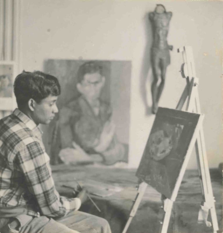 Albert Adams seated at easel in his studio, London