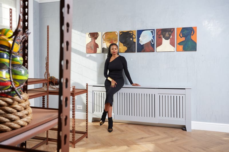 Nomaza Nongqunga next to paintings by Nthabiseng Boledi Kekana