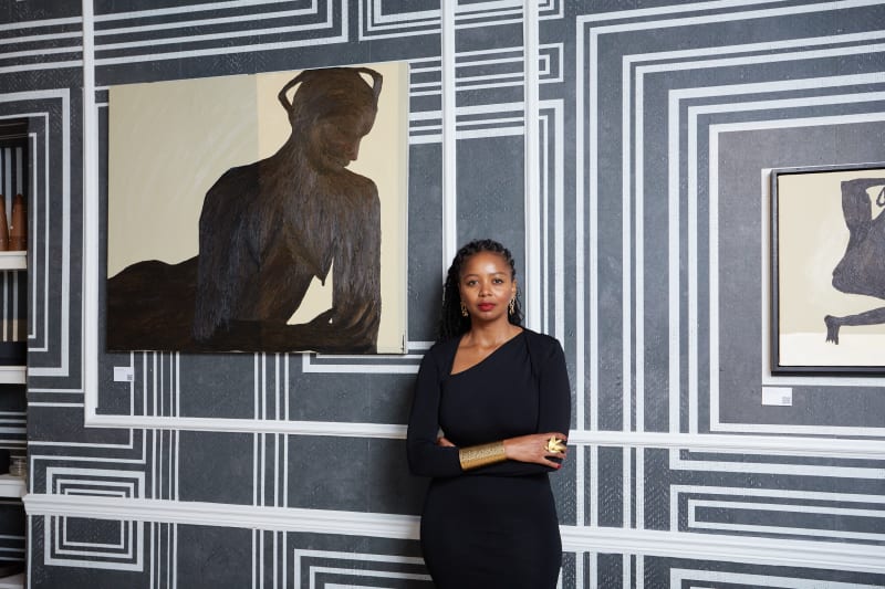 Nomaza Nongqunga next to paintings by Nthabiseng Boledi Kekana