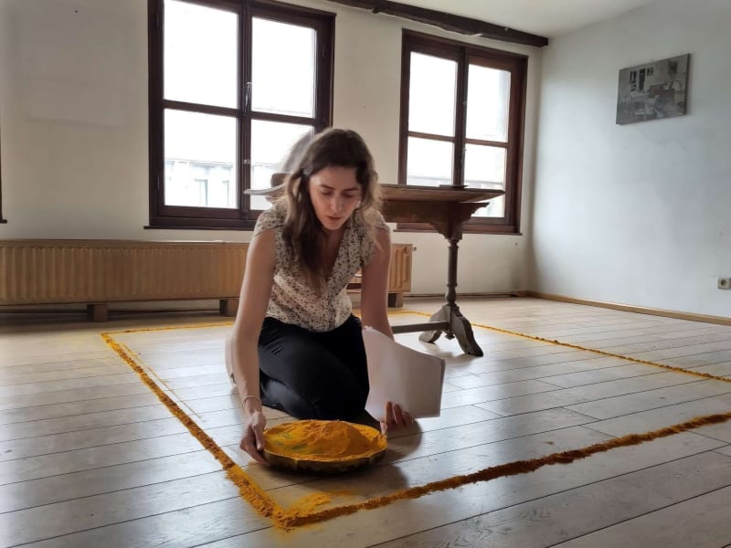 Geb Ich Dir (Laurence Petrone liest Bernd Lohaus) / 2023, 50’ (Kleine Goddaard, Antwerp). Word paper, table, chair, azobe wood, stone, silence, body, turmeric. Photo: Flor Maesen