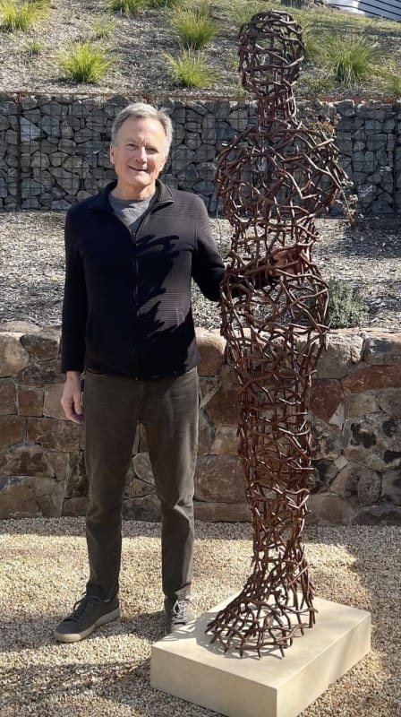 The contemporary sculptor, Tor Archer, next to his life-size sculpture of a female, formed by copper twigs