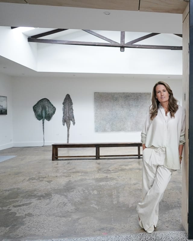 Kelli Lundberg in the art gallery kellilundberg.art with artworks by Neil Williams and Emma Davies in the background