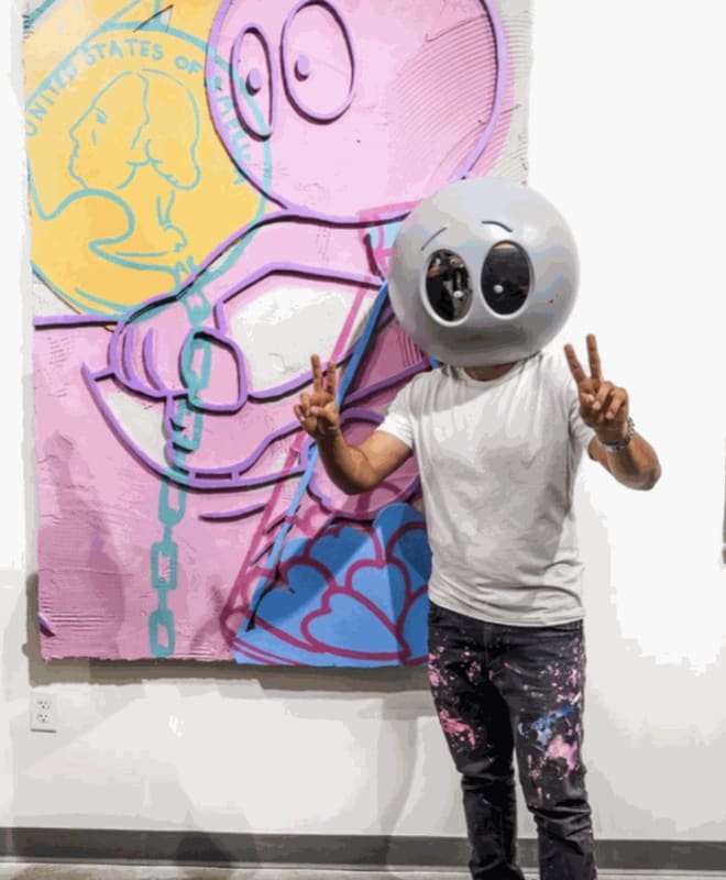 Artist Kaï wearing an alien head on his face.