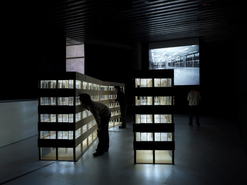 Building, 2006, A model of a Building made of wood and acryl, 4 video cameras, fluorescent lamp, video projector, motor, 300x600x190cm 빌딩, 2006, 나무, 아크릴, 형광등, 5대의 소형 비디오카메라, 4개의 모터, 비디오 프로젝터, 300x600x190cm