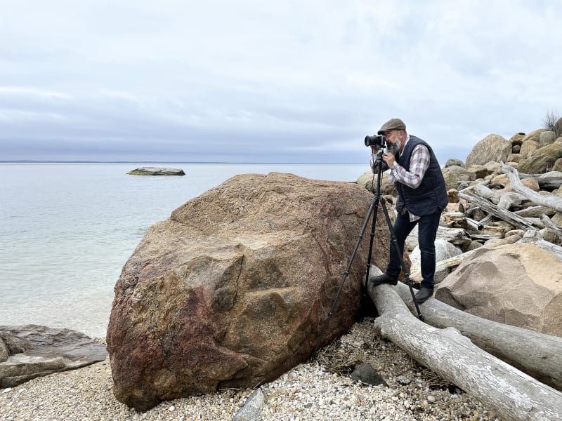 The photographer David Magee on location with his camera on a waters edge.