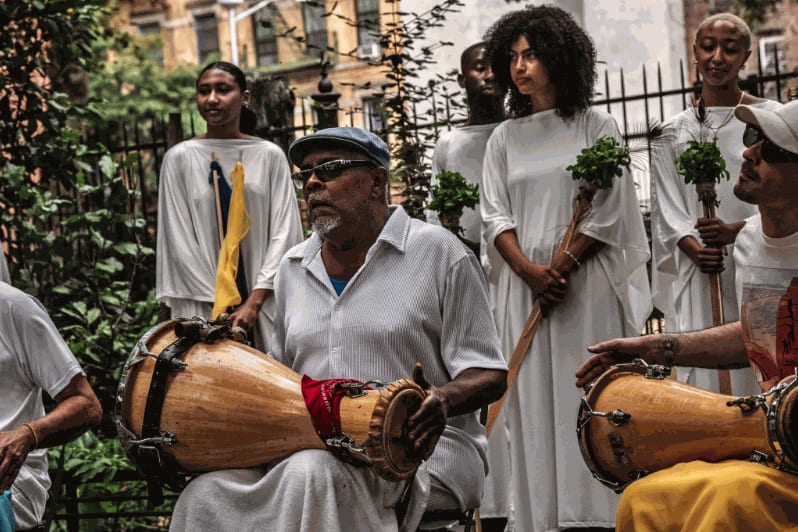 The procession stopped for a performance by the group Belongó. Credit: Graham Dickie/The New York Times