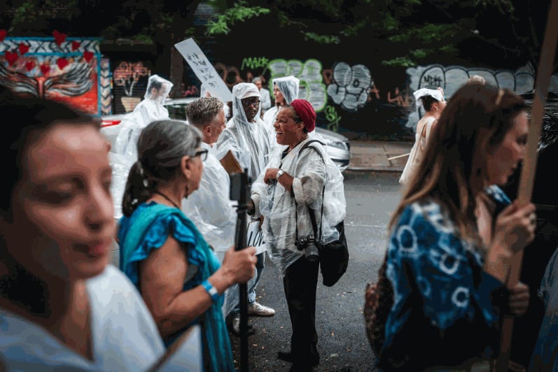 Center, in red hat, the artist Carrie Mae Weems, who participated in the procession. Credit: Graham Dickie/The New York Times