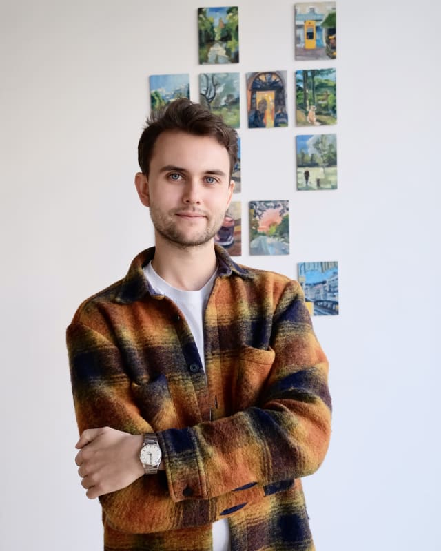 Image from Jérémie Queyras’ Phonescapes exhibition at OFFMARKET Gallery. The first shows a grid-style wall installation of small, colourful oil paintings depicting landscapes, architecture, and everyday scenes. The second shows the artist standing in fron